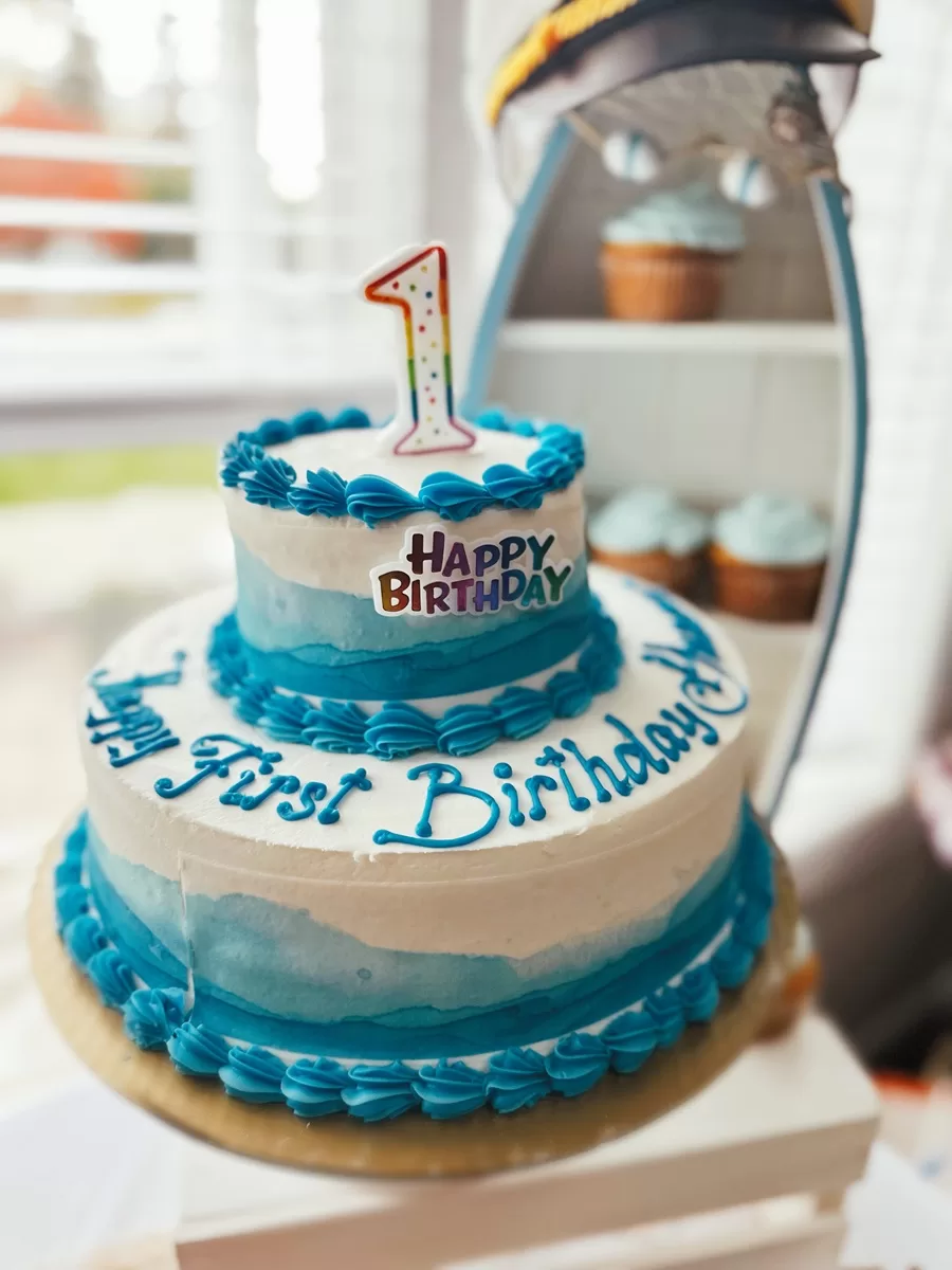 first birthday cake with blue waves along the side