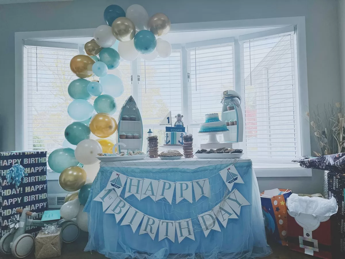 blue nautical party dessert table with balloon arch