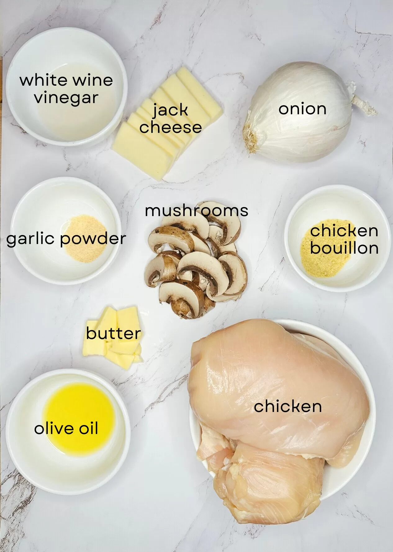 ingredients for smothered chicken on white marbled background