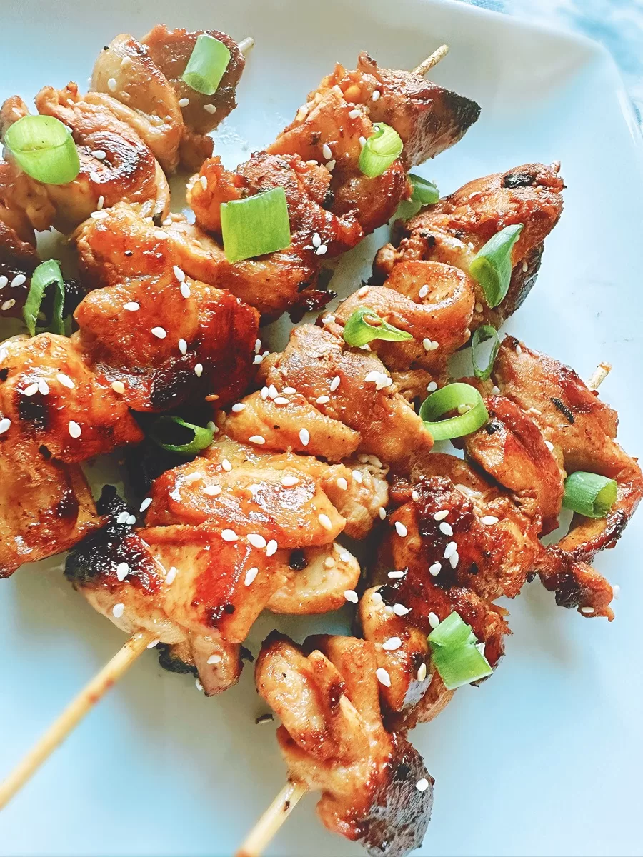 chinese chicken on a skewer with sesame seeds and green onion