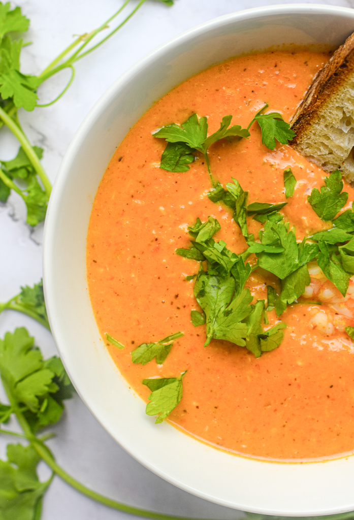 close up shot of seafood bisque with fresh herbs
