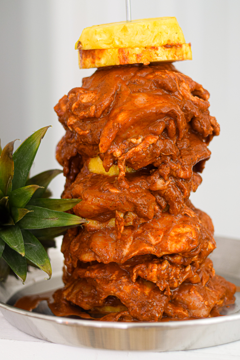 raw marinated chicken skewered with a pineapple on top