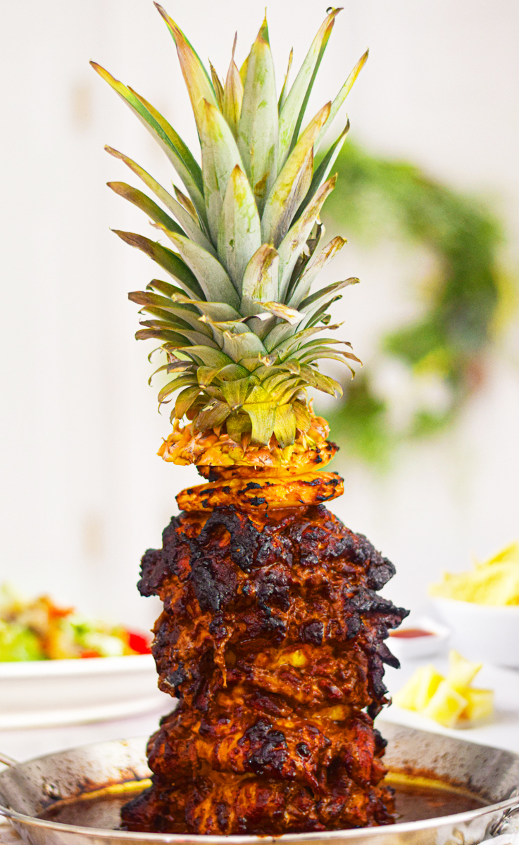 chicken al pastor on a skewer with a pineapple on top