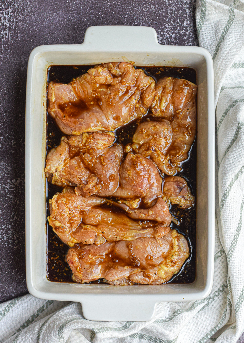 uncooked honey garlic chicken thighs in a baking dish