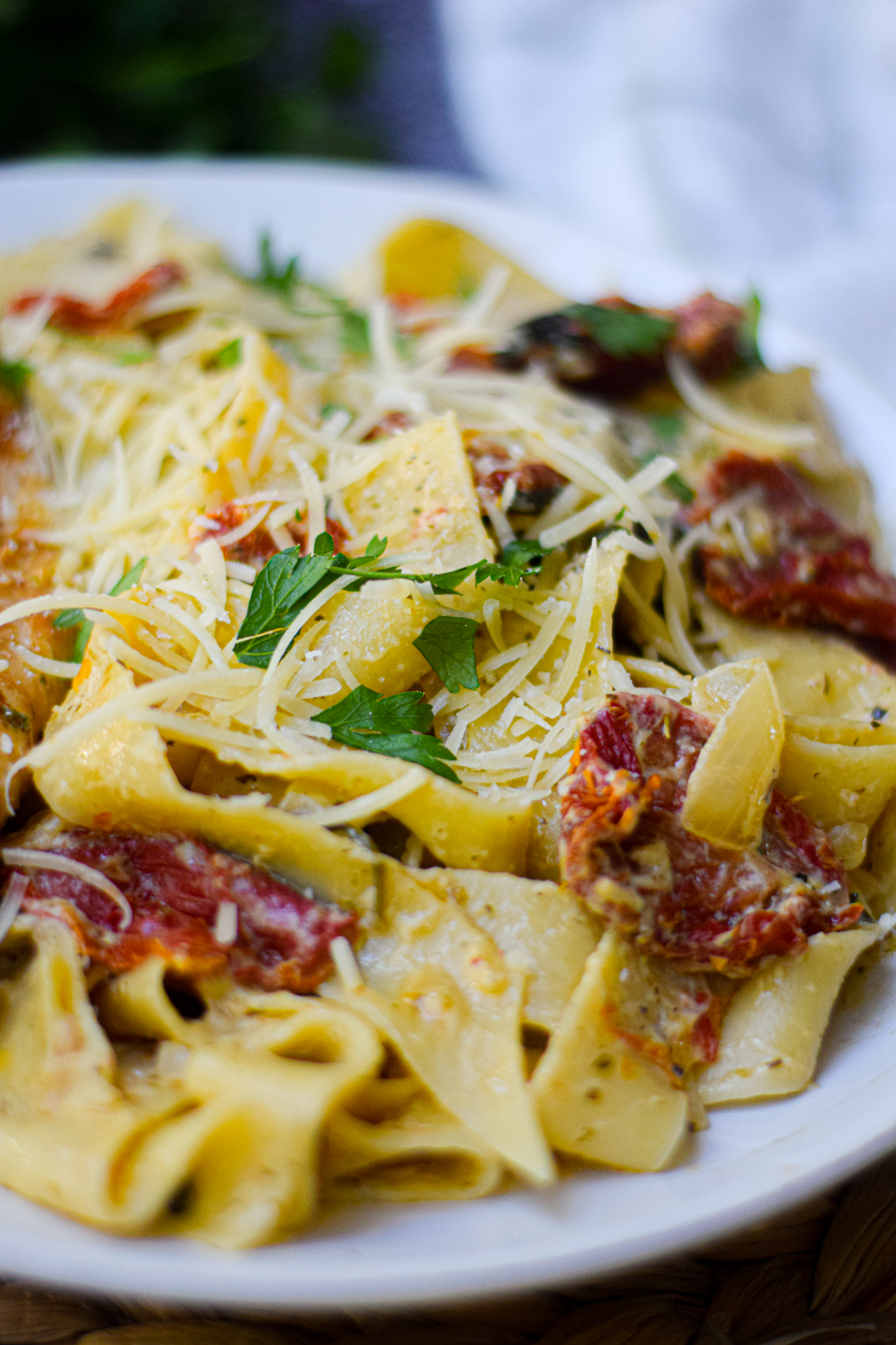 creamy tomato pesto pasta closeup on a white dinner plate