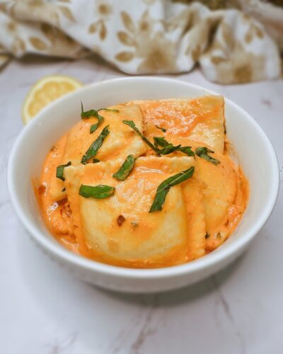 lobster ravioli with pink sauce in a white bowl