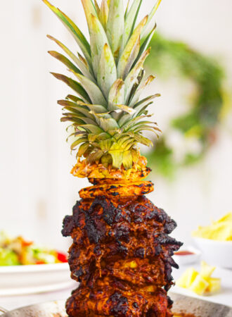 chicken al pastor on a skewer with a pineapple on top