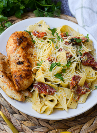 creamy tomato pesto pasta on a white dinner plate