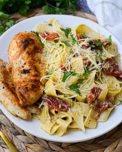 creamy tomato pesto pasta on a white dinner plate